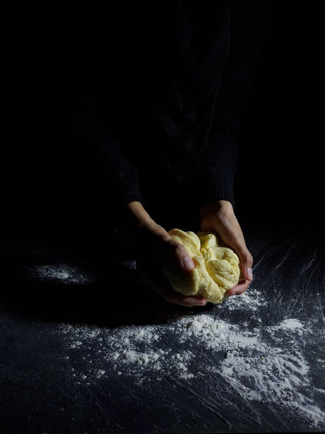 Las mujeres hacen masa de harina a mano. Fotografía de cuentos para hornear. Humor oscuro. - Foto, Imagen
