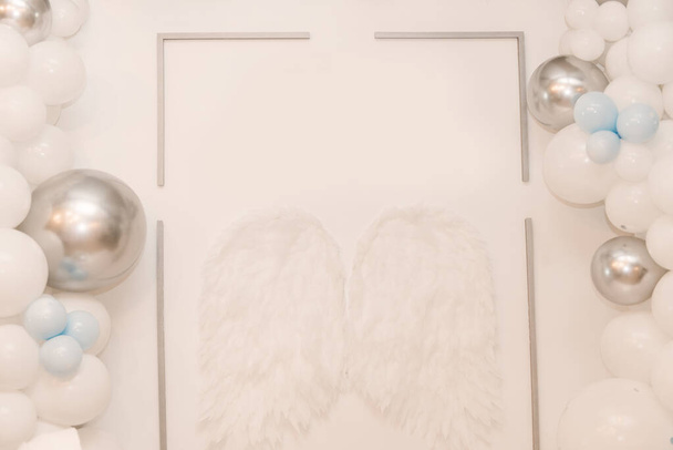 Gyönyörű fehér fotózóna léggömbökkel és angyalszárnyakkal - Fotó, kép
