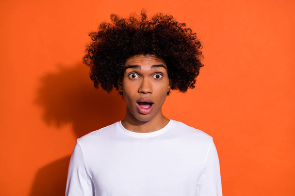 Photo of young astonished man crazy fake information open mouth isolated over orange color background - 写真・画像