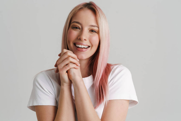 Young woman with pink hair smiling and looking at camera isolated over white background - Zdjęcie, obraz