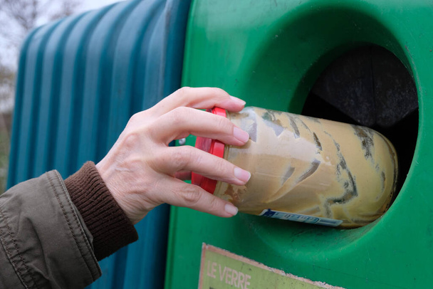 Kézzel dobott egy üveg üveget egy francia újrahasznosító kukába - Fotó, kép