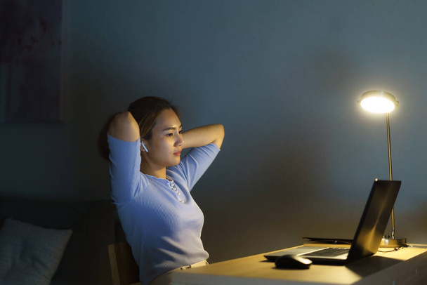 Asian business woman stress out with project business plan on computer laptop or notebook at home office at night. Asian people occupational burnout syndrome concept. - 写真・画像
