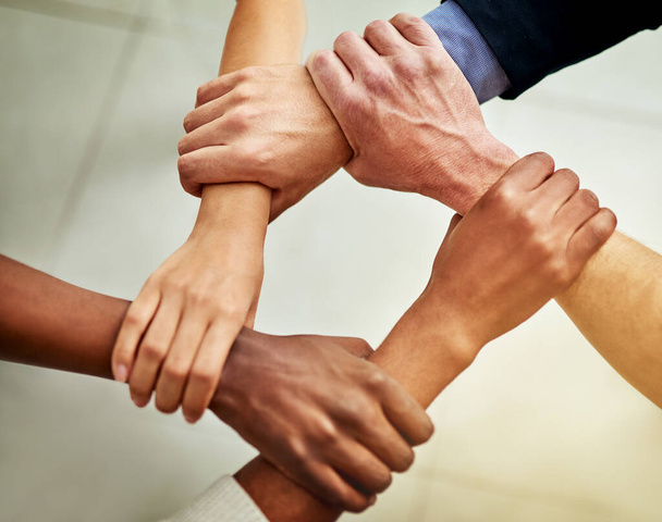 Los fuertes vínculos crean equipos fuertes. Recorte de un grupo de empresarios que unen sus brazos en solidaridad. - Foto, imagen