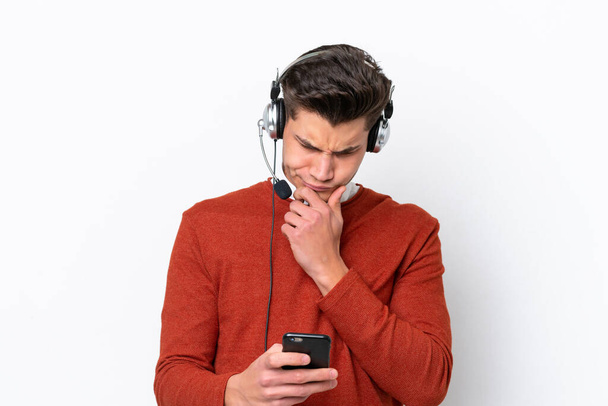 Telemarketer καυκάσιος άνθρωπος που εργάζονται με ένα ακουστικό που απομονώνονται σε λευκό φόντο σκέψης και την αποστολή ενός μηνύματος - Φωτογραφία, εικόνα