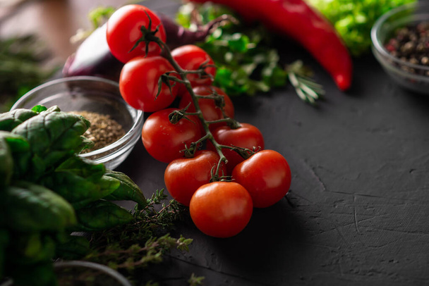 Branch of cherry tomatoes. Dark background. Various vegetables. Vegetarian food. Raw food diet. - Foto, Imagem