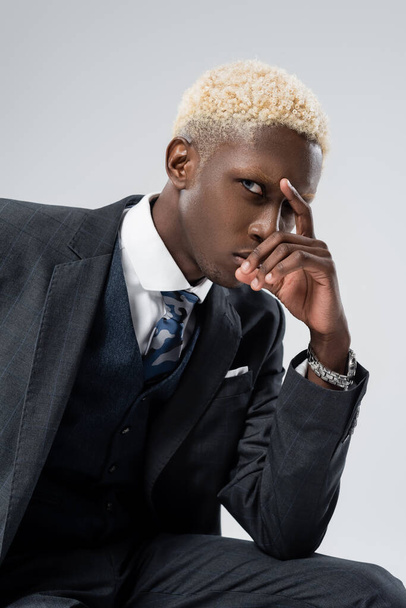 blonde african american man in formal wear looking at camera isolated on grey  - Фото, изображение