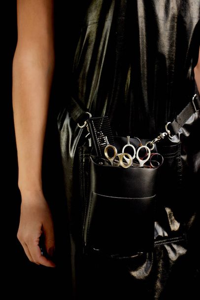 Leather handbag with hairdresser's tools - scissors and combs. hairdresser girl with tools - 写真・画像