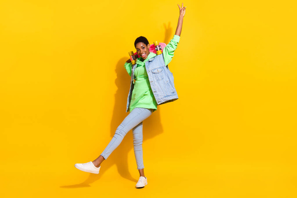 Full body portrait of funny youngster skate fingers demonstrate v-sign friendly isolated on yellow color background - Foto, Imagen