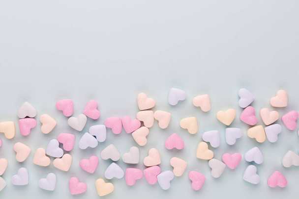 Valentine's Day background. Composition with candy hearts on pastel blue background. Valentines Day greating card. Flat lay, top view. - Fotografie, Obrázek