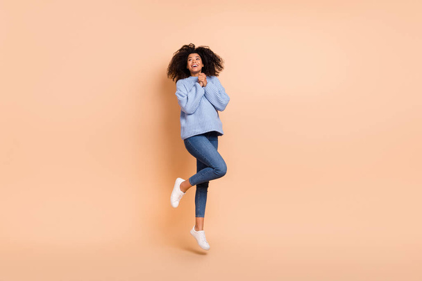Volledige lichaamsomvang uitzicht van aantrekkelijke vrolijke verbaasd blij meisje springen hoop bidden geïsoleerd over beige pastel kleur achtergrond - Foto, afbeelding