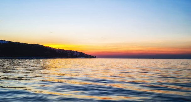 Slovenya 'nın Izola kentinde görülen Adriyatik Denizi üzerinde güneş batıyor. - Fotoğraf, Görsel