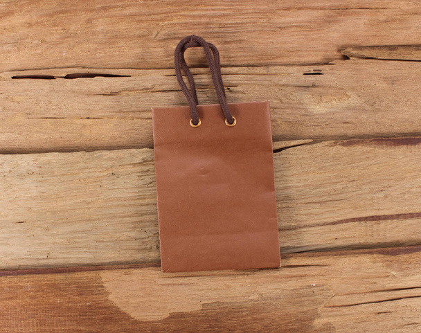 paper bag backside on old wooden background for natural recycle concept - Foto, Imagem