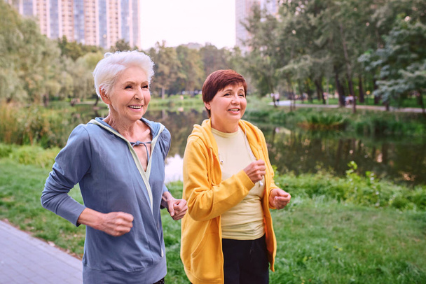 Parkta koşan iki olgun kadın. sağlıklı yaşam tarzı kavramı - Fotoğraf, Görsel