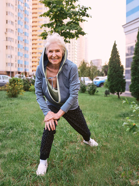 Starsza kobieta ćwiczy sport w parku. koncepcja zdrowego stylu życia - Zdjęcie, obraz