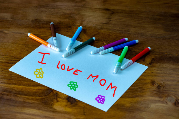 Kid drawing of Mother holding his child for happy mother's day theme with I LOVE YOU MOM message. - Zdjęcie, obraz