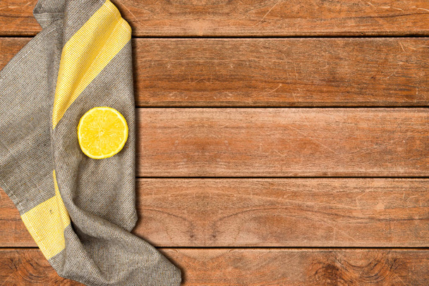 Lemon slice above napkin on wooden table - Photo, Image