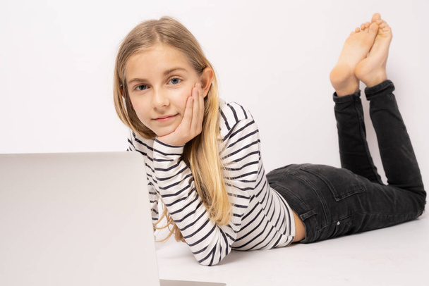 Giovane ragazza zenzero posa sul pavimento utilizzando computer portatile isolato su sfondo bianco. - Foto, immagini