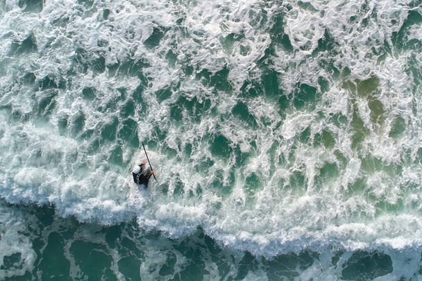 Бриттани, Франция - 06 октября 2021 года: Встаньте в паддл (SUP) спортсмены сверху. 1 человек занимается водным спортом на море. Вид с воздуха с беспилотника. - Фото, изображение