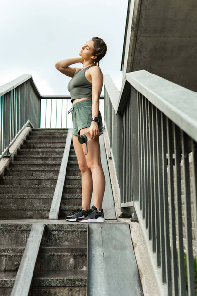 Beautiful sportive woman after fitness or jogging workout on a city street - Fotoğraf, Görsel