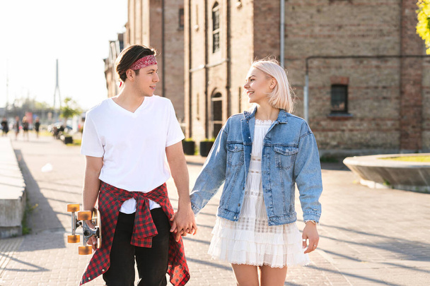 Stylish teenage couple with a longboard during their date in a city - Photo, image
