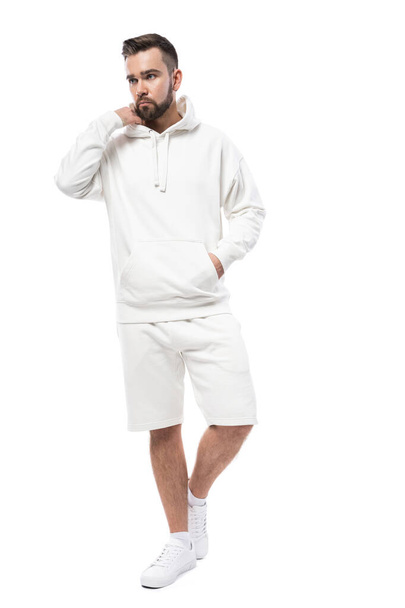 Handsome man wearing blank white hoodie and shorts isolated on white background - Fotó, kép