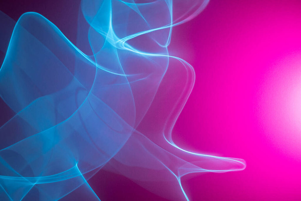 Neon abstracte led lijnen op een magenta achtergrond. Fluorescerende cyberpunk achtergrond. - Foto, afbeelding