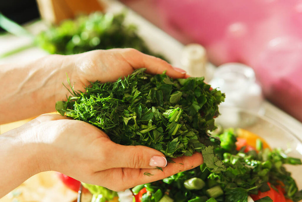 Closeup of female hands with chopped green dill and parsley - Foto, imagen