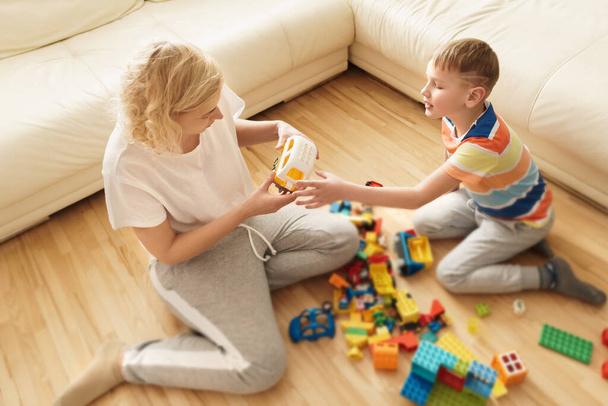 Cute boy and his happy mother playing together at home - Fotoğraf, Görsel