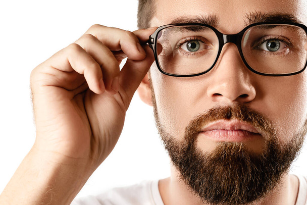 Young and handsome bearded man wearing eyeglasses on white background - Foto, afbeelding
