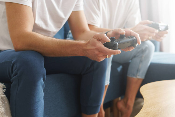Couple avec une manette de jeu jouent console de jeu vidéo à la maison - Photo, image
