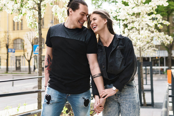 Portrait of happy laughing couple having fun during their date on a city street - 写真・画像