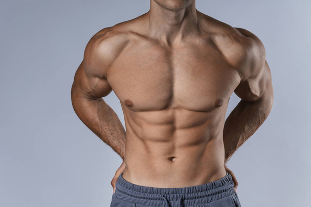 Bodybuilding and fitness - muscular male torso against gray background - Φωτογραφία, εικόνα