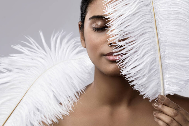Portrait of young and sensual Indian woman with a soft ostrich feather - Foto, afbeelding