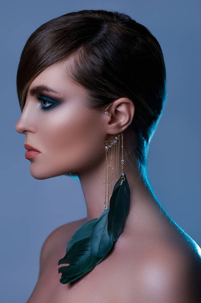 Portrait of sexy model in stylish image with sleek hair covering one eye and feather earring - Fotografie, Obrázek