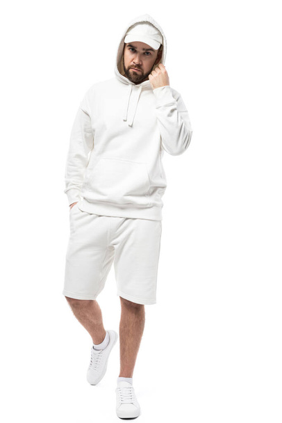 Handsome man wearing blank white cap, hoodie and shorts isolated on white background - 写真・画像