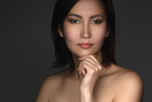 Skincare and spa. Portrait of young and beautiful asian woman on dark gray background - Photo, image