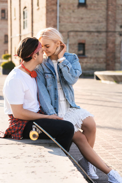 Stylish teenage couple with a longboard during their date in a city - Foto, imagen