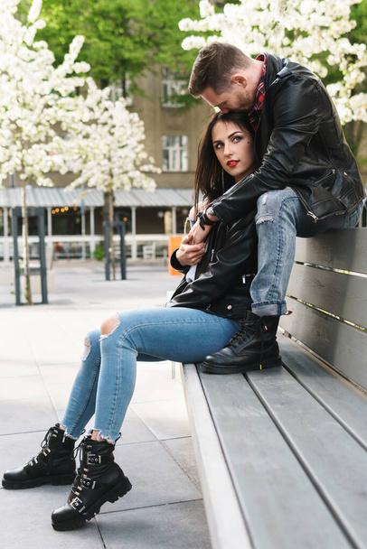 Young and beautiful couple in love wearing leather jackets during a date on a city street - 写真・画像