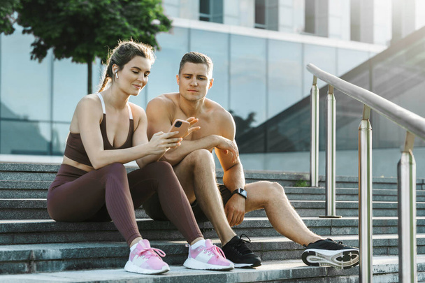 Young sportive couple relaxing after fitness workout outdoors - Valokuva, kuva