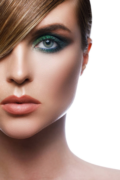 Sexy model in stylish image with sleek hair covering one eye and beautiful green eyeshadows on another against white background - Фото, зображення