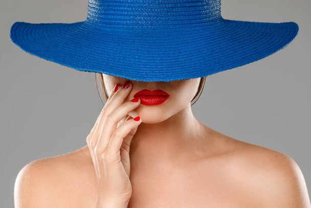 Portrait of stranger girl with red lips wearing blue hat on gray background - Foto, afbeelding