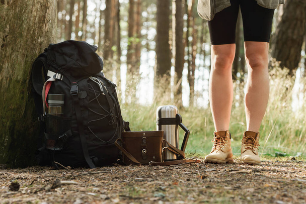 Forest hike - Female legs and hiker's backpack on the ground - Fotoğraf, Görsel