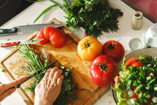 Frau hackt grüne Petersilie und Dill für gesunden vegetarischen Salat - Foto, Bild