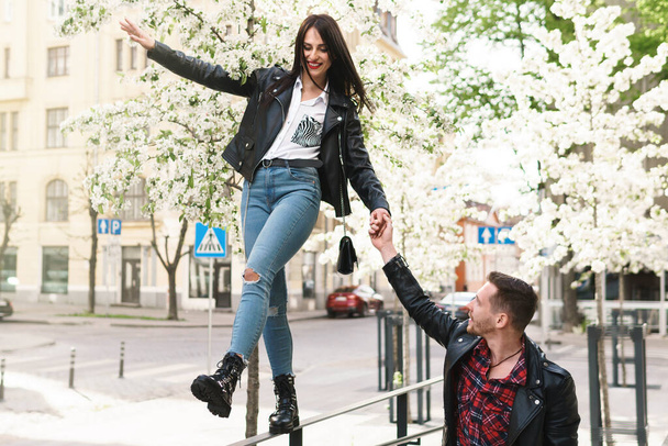 Young and beautiful couple in love wearing leather jackets during a date on a city street - Foto, Imagen
