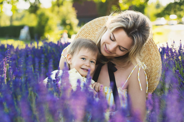 Beautiful young woman and her cute little son in the lavender field - Foto, imagen
