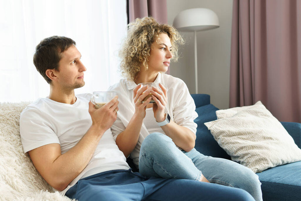 Young happy couple spending time together and drinking coffee at home - Photo, Image