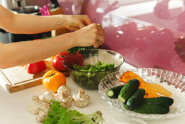 Woman cooking vegetarian salad with fresh vegetables - 写真・画像