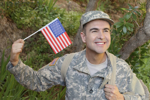 primer plano retrato de guapo joven soldado en uniforme con bandera de EE.UU. - Foto, imagen