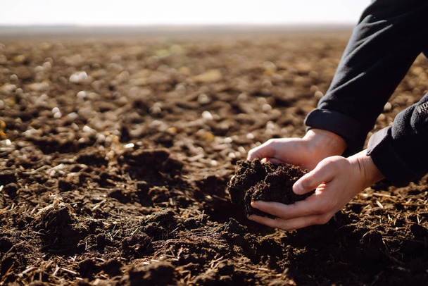 Hand of expert farmer collect soil and pouring to another hand to check quality and prepare  soil at farm field. Agriculture, gardening or ecology concept. - Foto, imagen