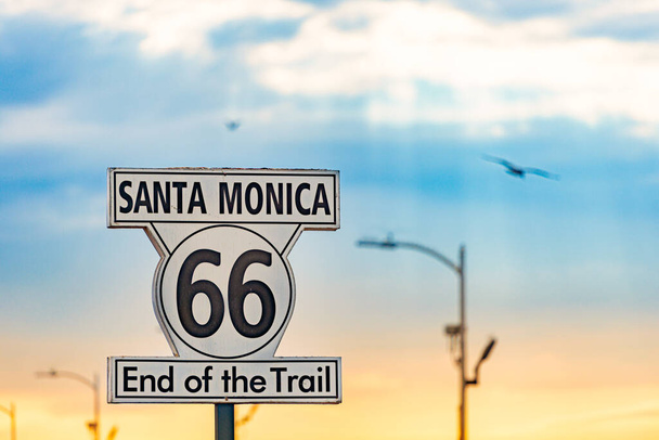 Santa Monica yolu 66 tabelasının sonunda. Chicago 'dan Los Angeles, California' ya otoyol. Arka planda gün batımı gökyüzü. - Fotoğraf, Görsel